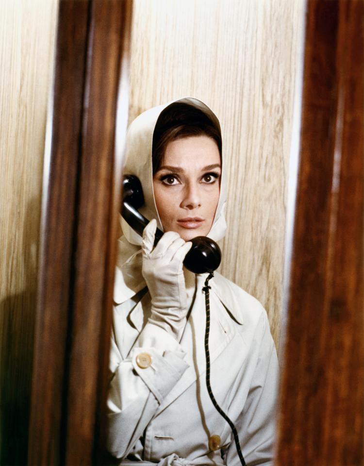  1963: Audrey looks elegant in a trench coat on the set of Charade