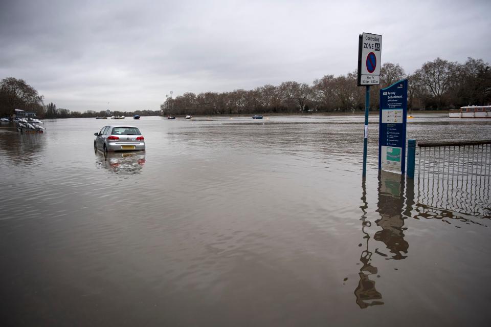  A car is stranded as the swollen River Thames burst its banks at high tide in Putney, South West London