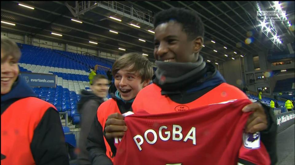  Everton's ballboy proudly shows off the Manchester United ace's shirt