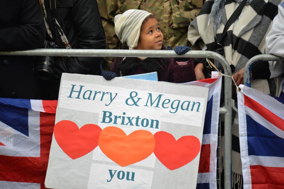  A child smiles next to a sign supporting the newly engaged couple