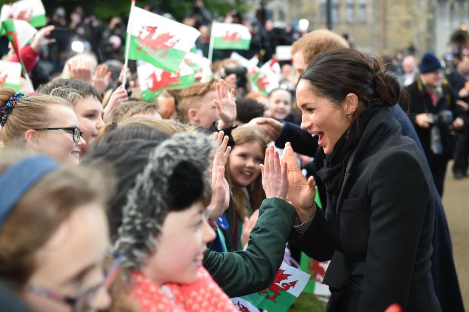  HIGH FIVE . . . Meghan slapped hands with members of the public