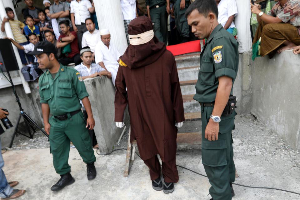  A sharia executor called an 'algojo' arrives to administer the punishments