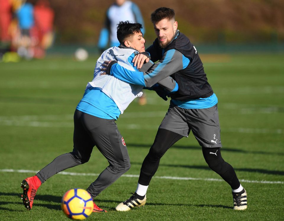  Alexis Sanchez is grappled by Mathieu Debuchy during the Gunners training