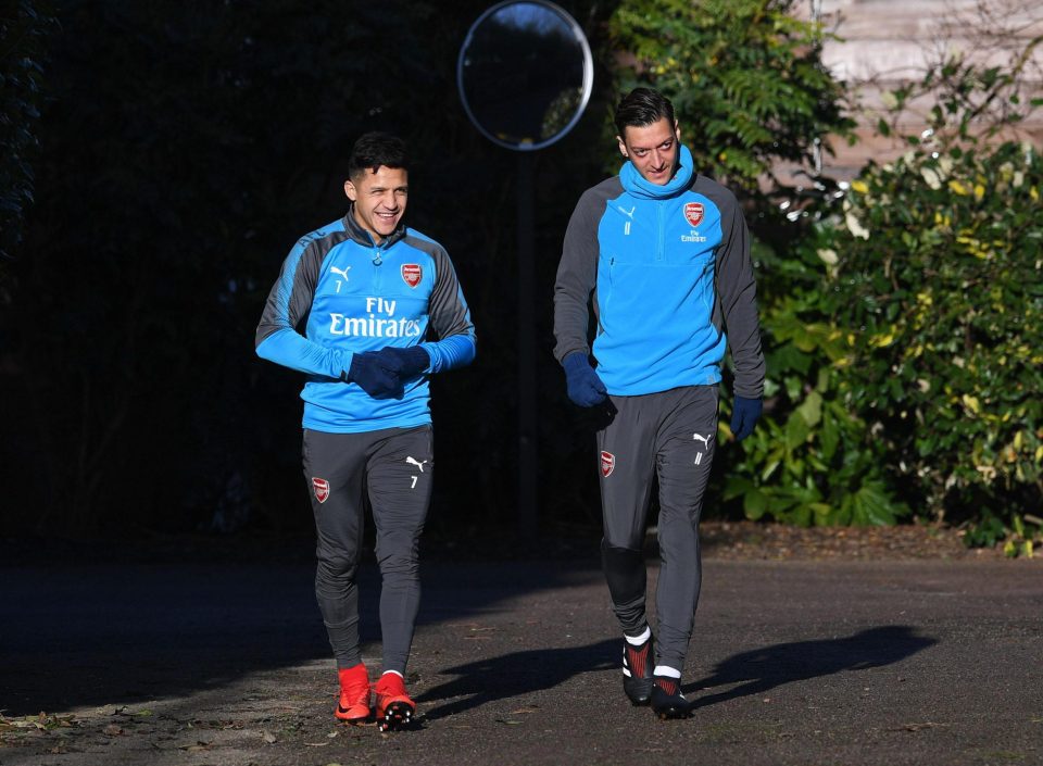  Sanchez and Mesut Ozil walk out for Friday's training session