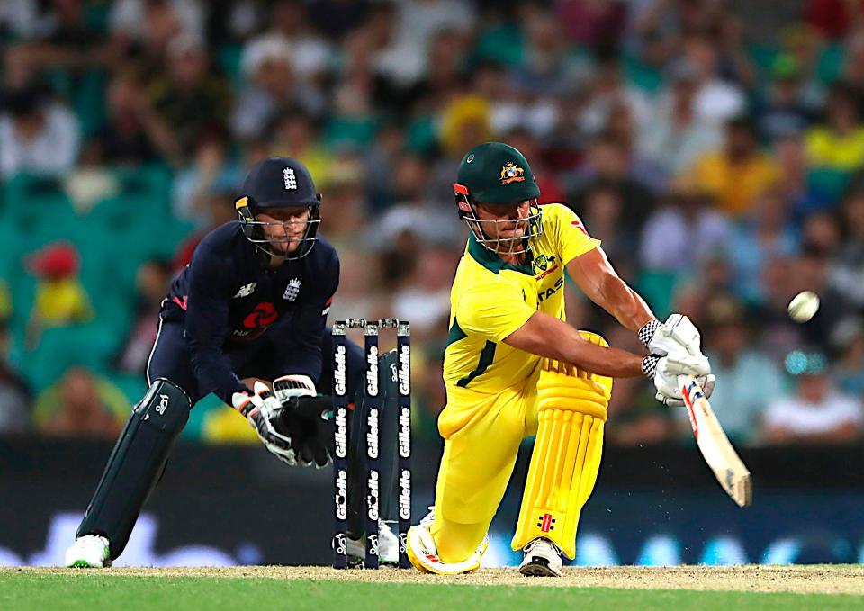  Australia's batsman Marcus Stoinis sweeps as England's wicketkeeper Jos Buttler looks on,