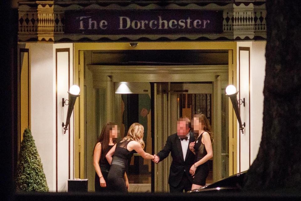  An elderly balding guest with three young hostesses at the scandal-ridden hotel