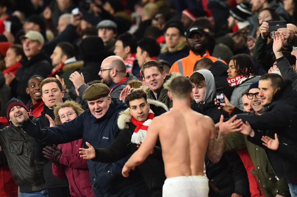  Wilshere celebrates with fans after the win over Chelsea