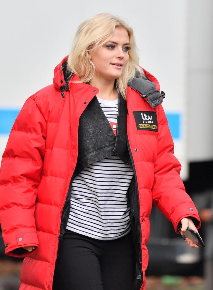  Lucy looked cosy in her red puffa jacket during a break from filming