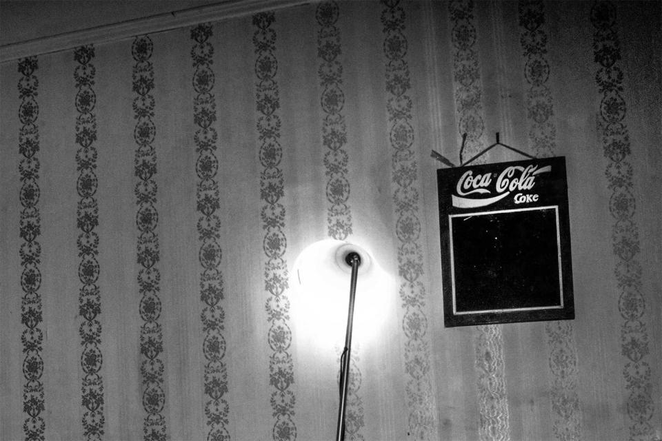  An empty blackboard with a Coca-Cola design is pinned to a wall