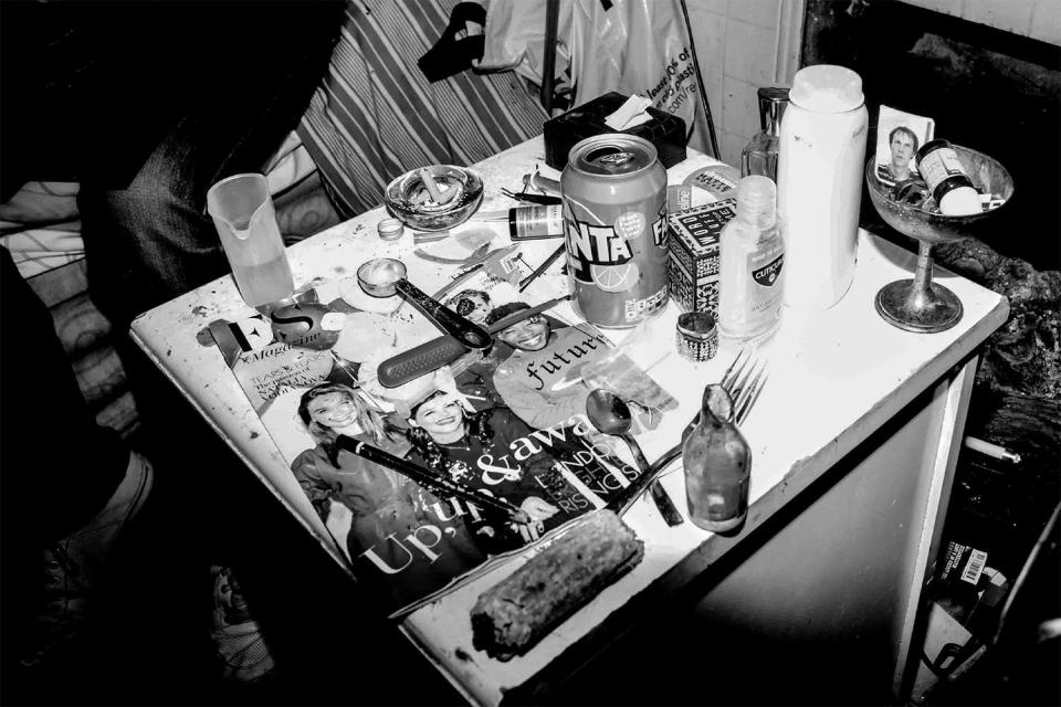  Drug paraphernalia including a makeshift crack pipe fashioned from a glass bottle litter this table