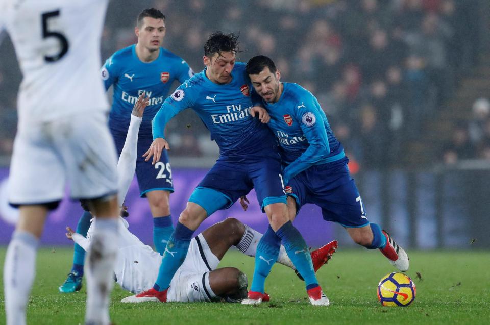  Mkhitaryan and Mesut Ozil collide in the second half at the Liberty Stadium