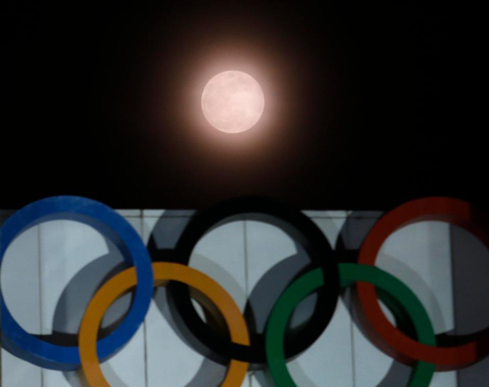  The full moon is seen over the Olympic rings on display at the Peace Gate at the Olympic Park in Seoul, South Korea