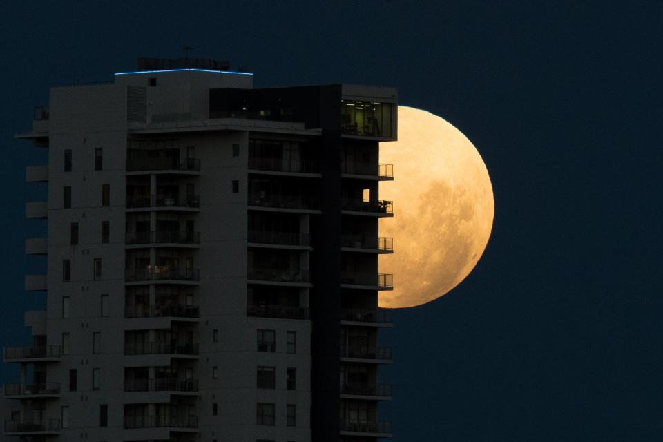  The weird super moon peaks out from behind a block of flats in Perth, in western Australia