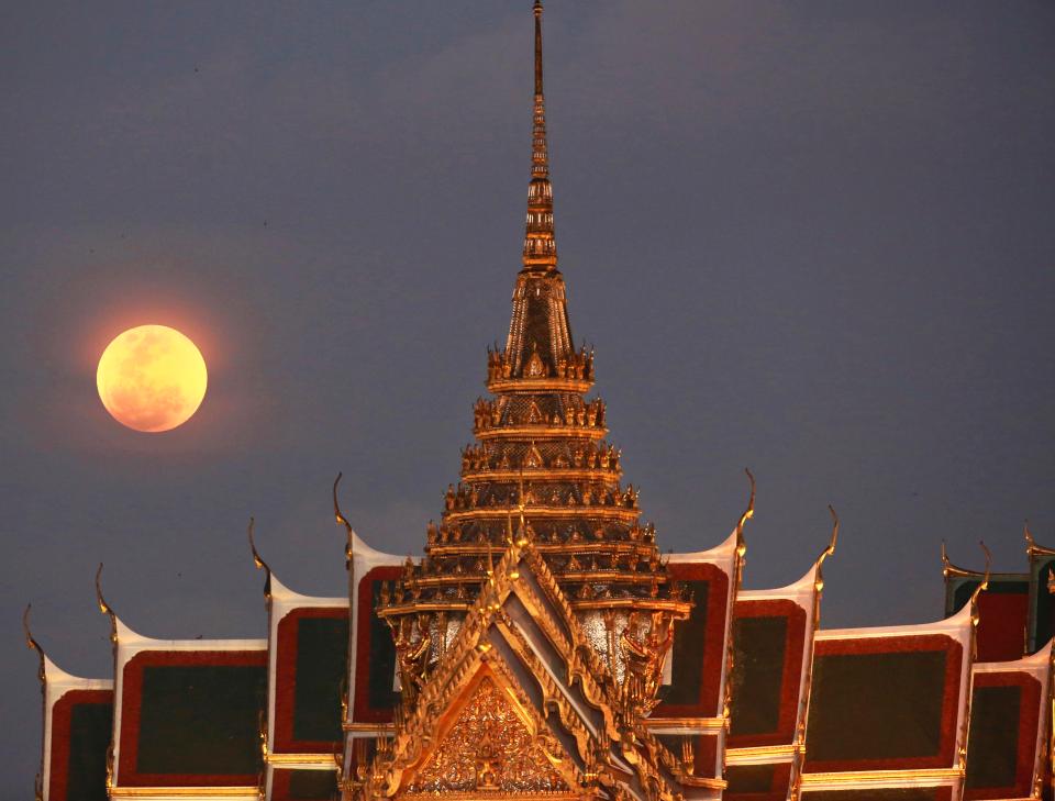  A full moon rises beside the Grand Palace in Bangkok, Thailand