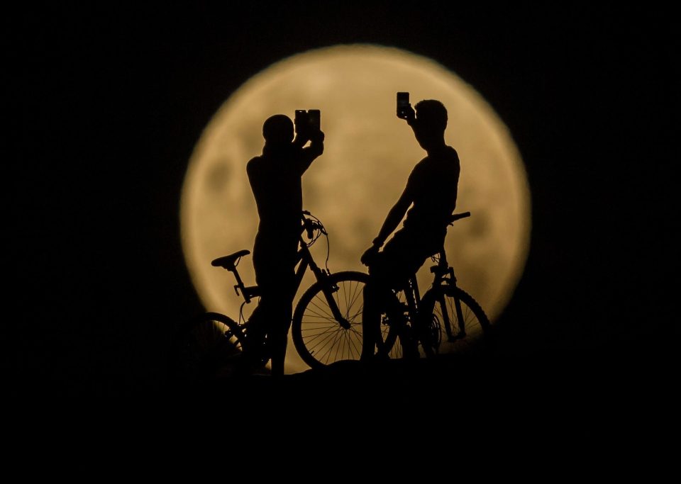  People with bicycles take photos of the super moon in Lancelin, Australia