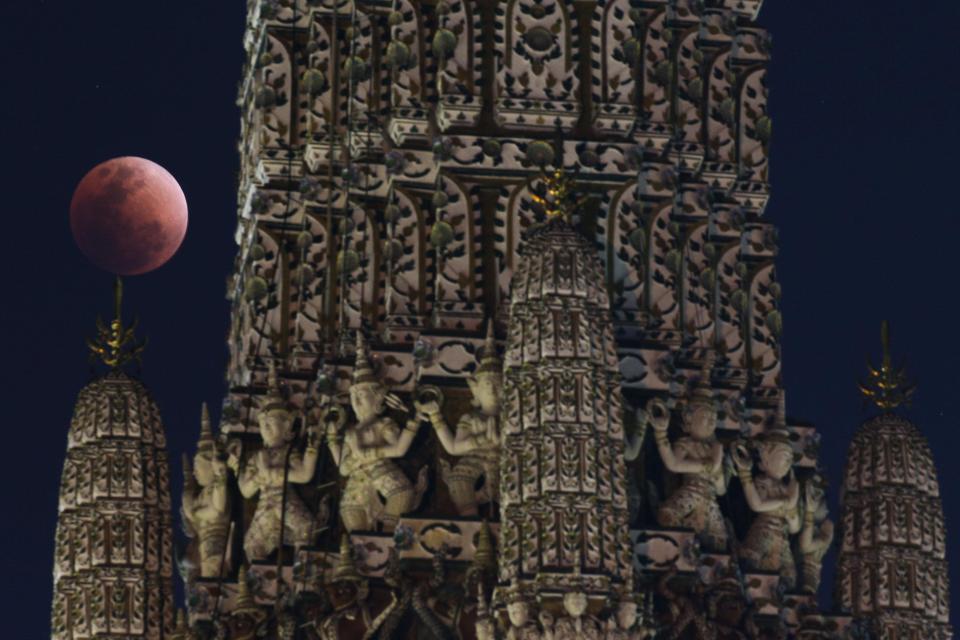  The moon is seen during an eclipse at a temple in Bangkok, Thailand