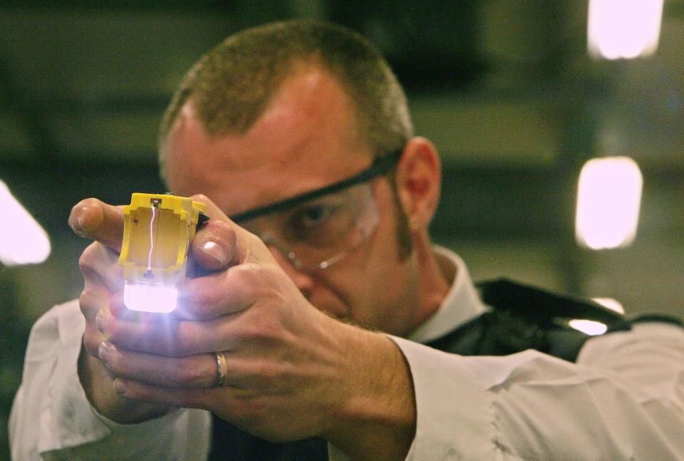  A police officer trains using a taser gun at the Metropolitan Police Specialist Training Centre