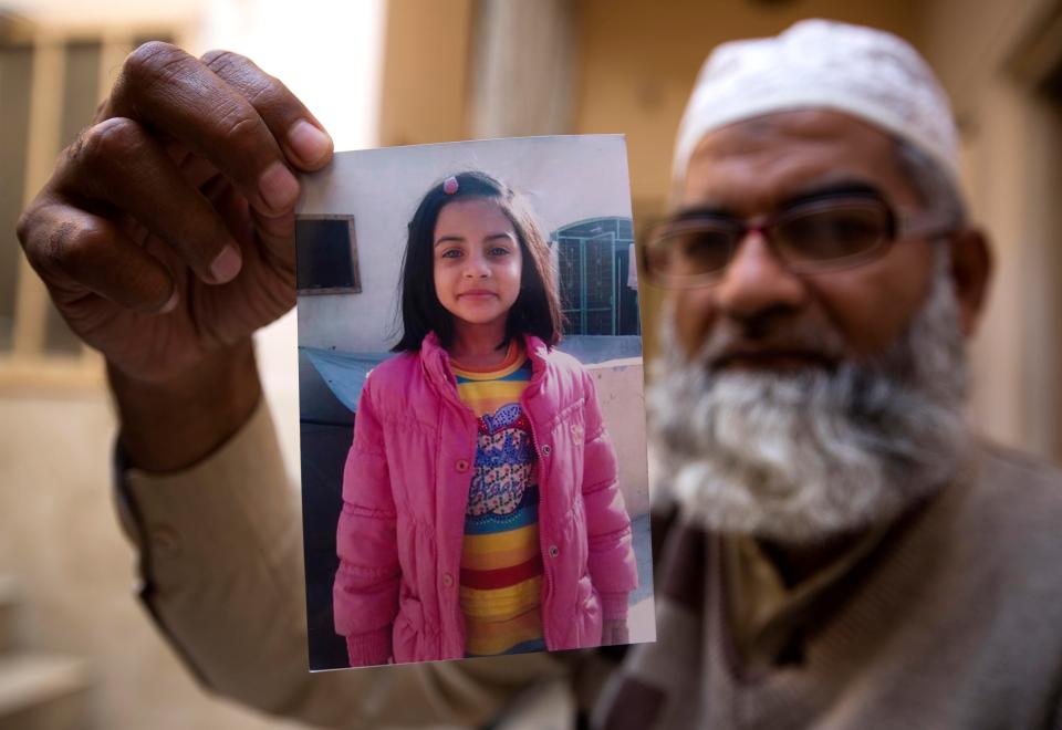  Mohammed Amin holds up a photo of his seven-year-old daughter, Sainab Ansari, who was brutally raped and murdered earlier this moth