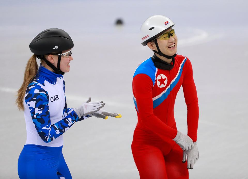  North Korean short track speed skater Jong Kwang Bom shares a joke with a Russian athlete