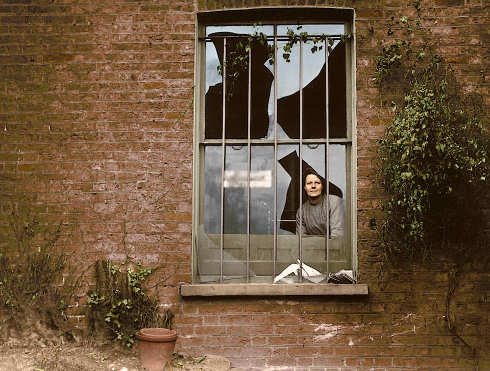  A woman peers through a smashed window at Holloway prison