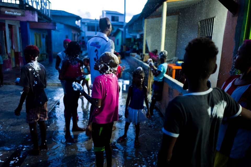 Youngsters appear to be washing themselves in the street