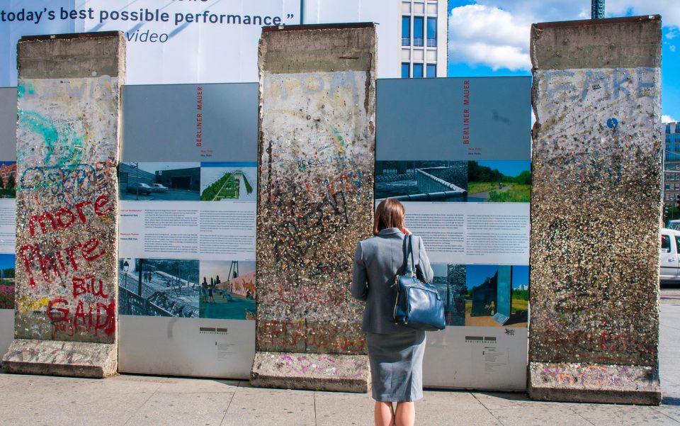  A tourist studies old segments of the Berlin Wall