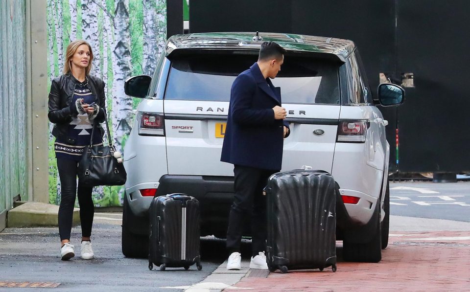  Man Utd star Alexis Sanchez prepares to help his girlfriend Mayte Rodriguez