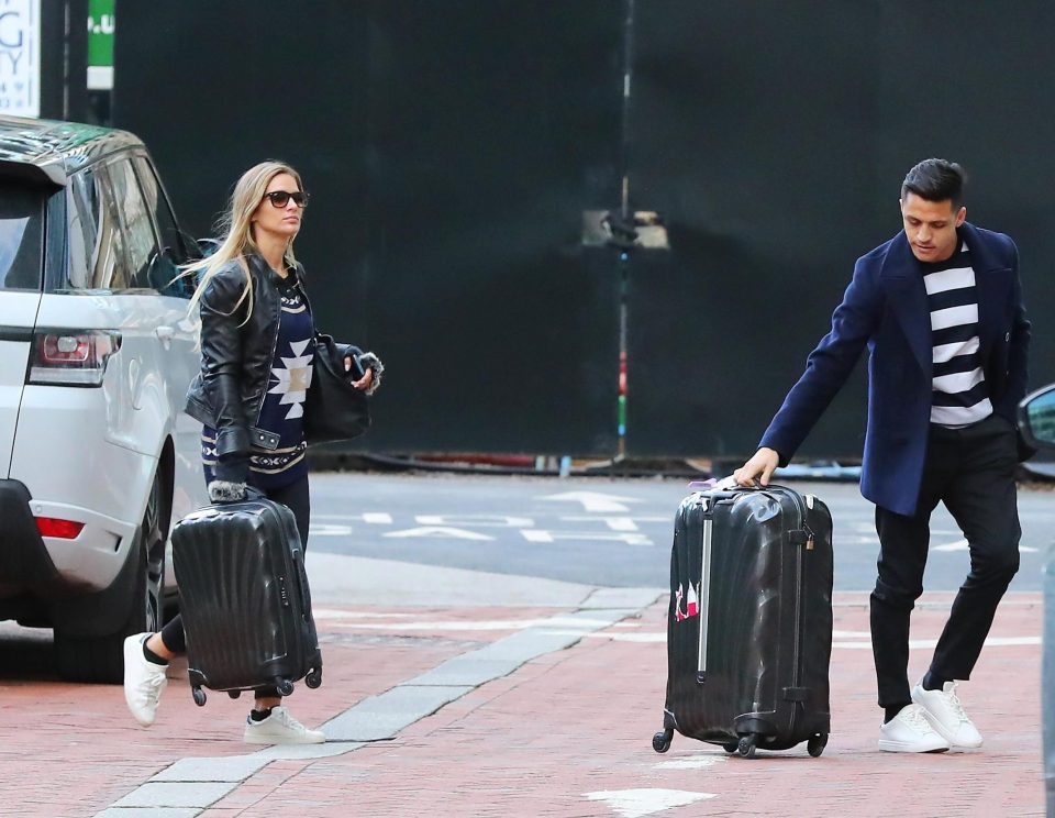  Alexis Sanchez wheels a suitcase in as girlfriend Mayte Rodriguez joins him