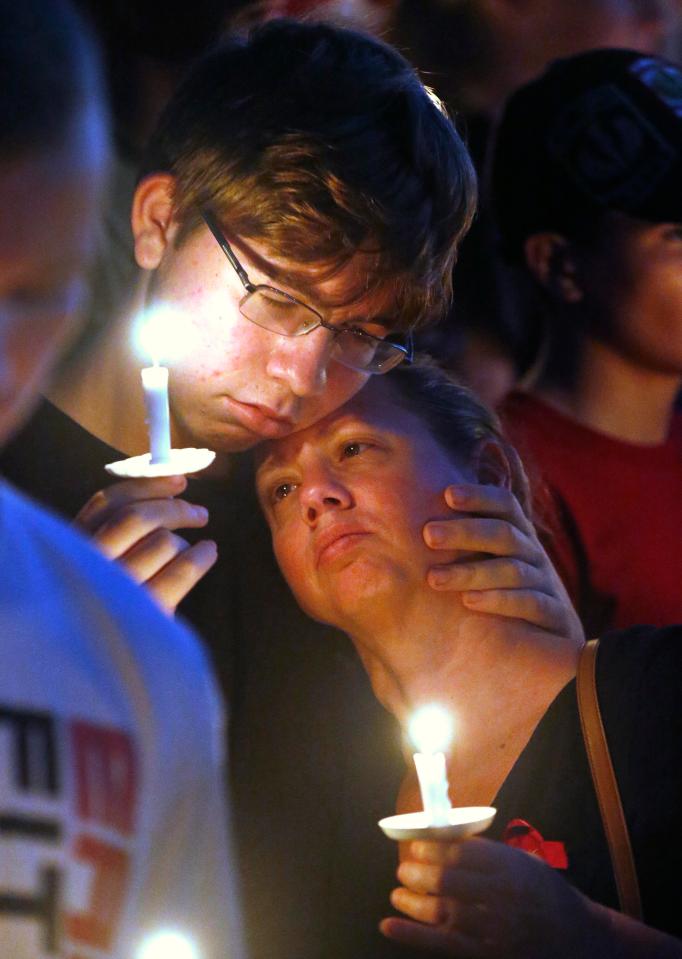  People held hands and comforted one another while paying respects to their loved ones