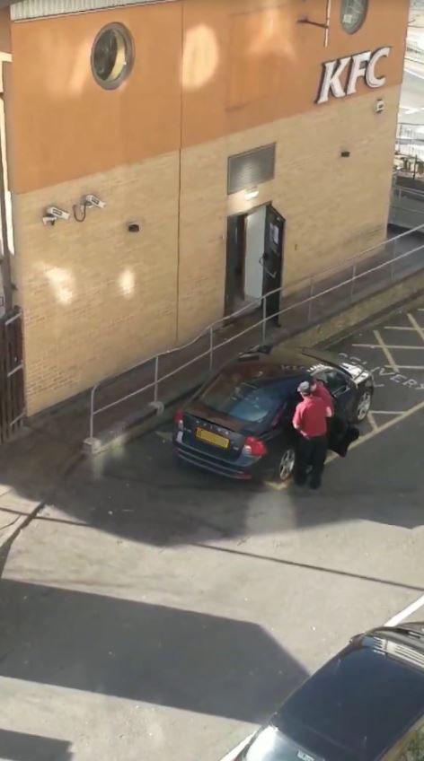  The video shows the workers pulling a box with black bags in from a car