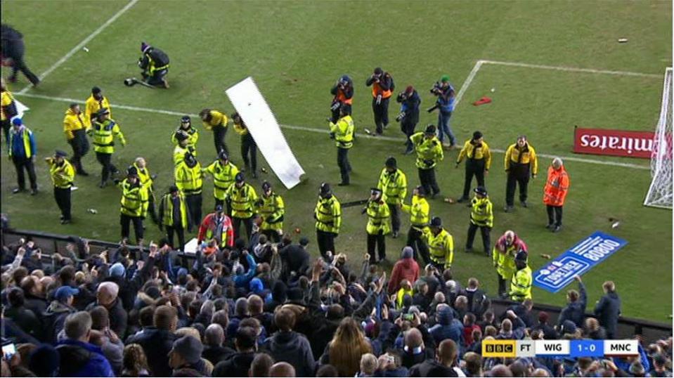  TV footage showed objects including bottles and seats being hurled from the away end