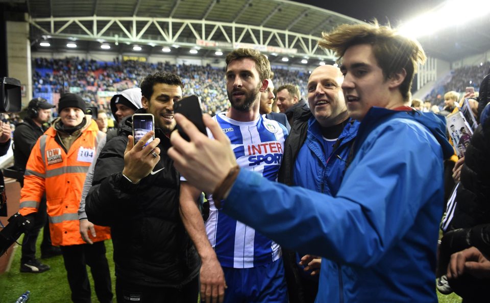  Will Grigg poses for a selfie with a Latics fan after their FA Cup shock