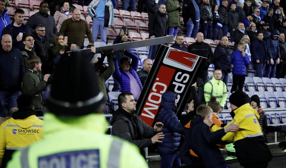  An advertising board flies out of the stands at the DW Stadium