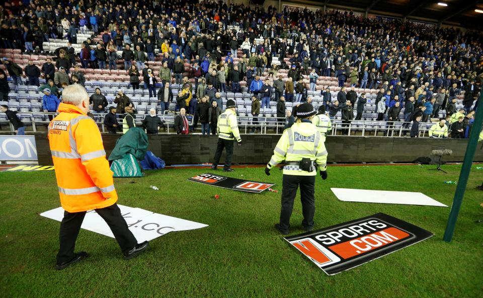  Advertising boards lie on the pitch after being thrown on by City fans