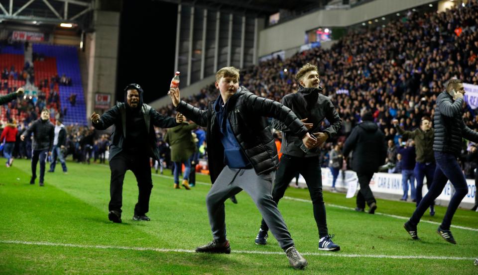  A fan throws a bottle towards supporters in the away end