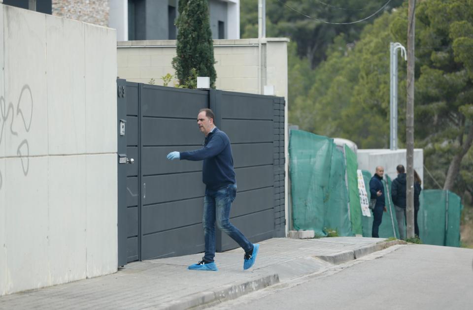  A policeman wearing gloves and bags over his shoes arrives at Philippe Coutinho's house to inspect the scene