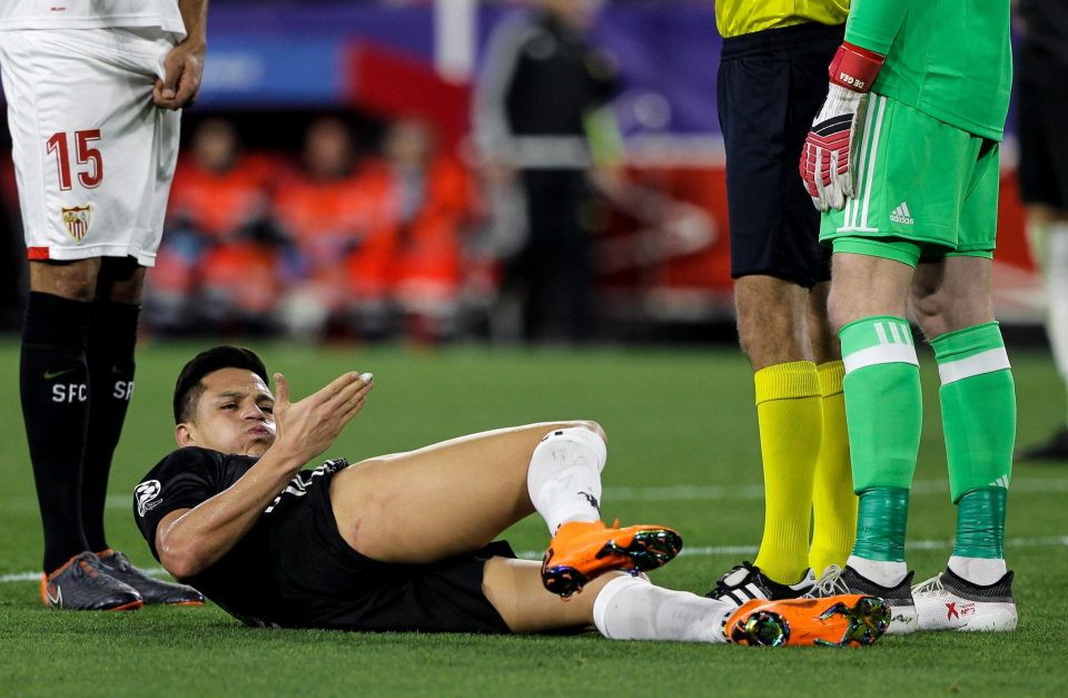  Alexis Sanchez lies injured following a heavy tackle during Sevilla clash