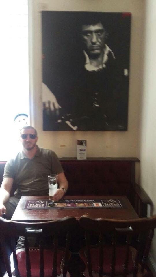  Stephen Pattison poses under a photo of Al Pacino in Scarface