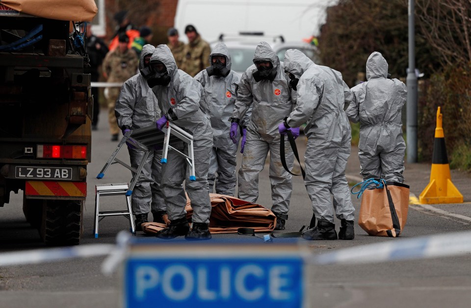 British Military personnel wearing protective coveralls work to remove a vehicle connected to the March 4 nerve agent attack in Salisbury