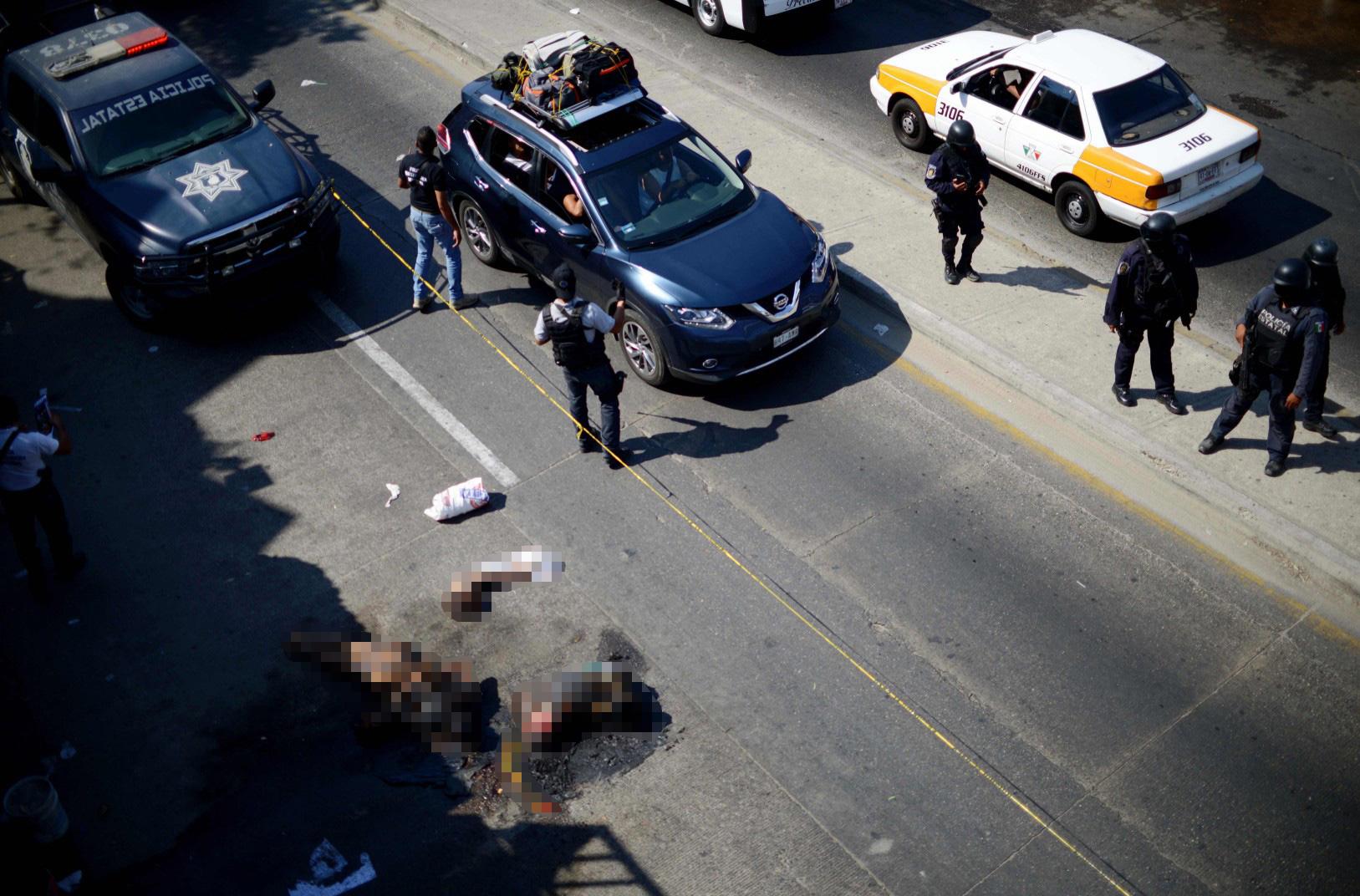  Tourists are forced to drive around the burnt and carved up remains of cartel victims in Acapulco, Mexico