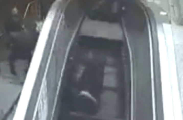  He loses his grip and falls onto the escalator which then gives way completely