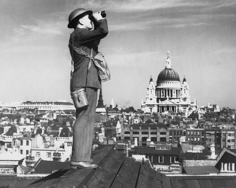  An aircraft spotter stands on the roof of a building London during the battle