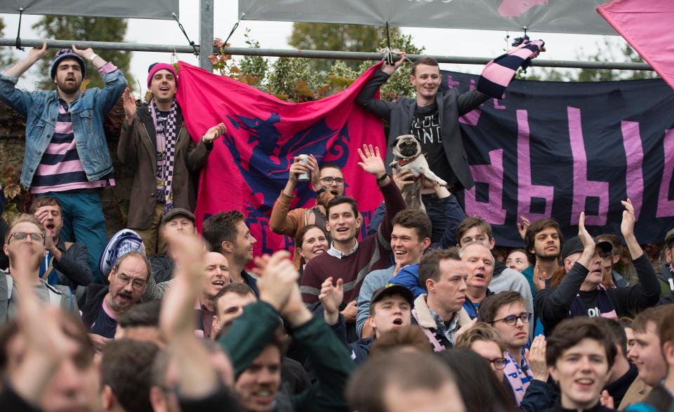  Dulwich Hamlet fans lift a fashionable pug dog at a home game