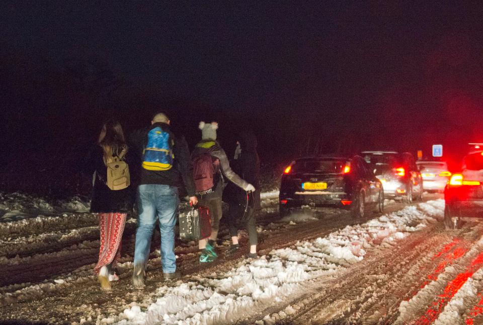  Stranded motorists walk through the snow on the A31 heading towards Dorset