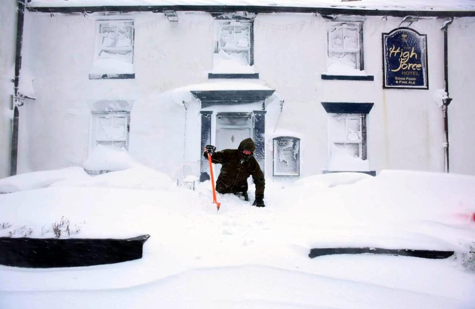  A man wades through snow blocking the path to a building in Forest-in-Teesdale in County Durham