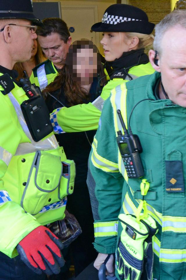  A woman is escorted out of the offices next to Zizzi restaurant