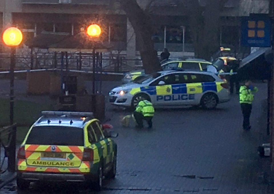  A police officer crouches down next to the shopping centre bench where Sergei and his daughter Yulia were found slumped unconscious