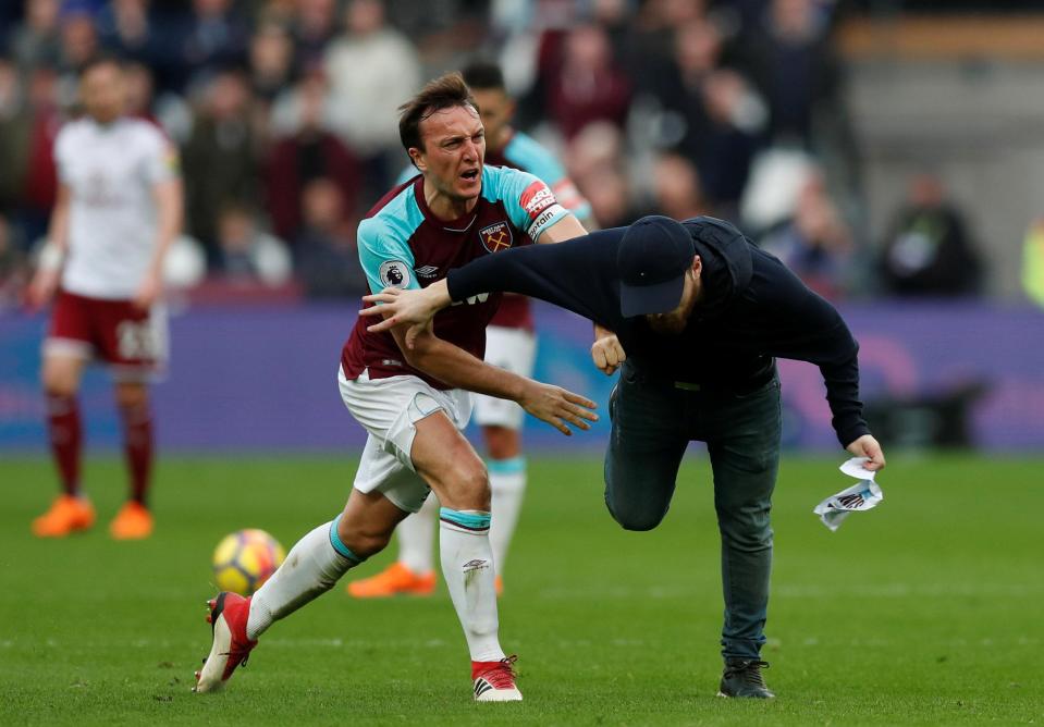  Mark Noble clashes with a fan who has invaded the pitch.