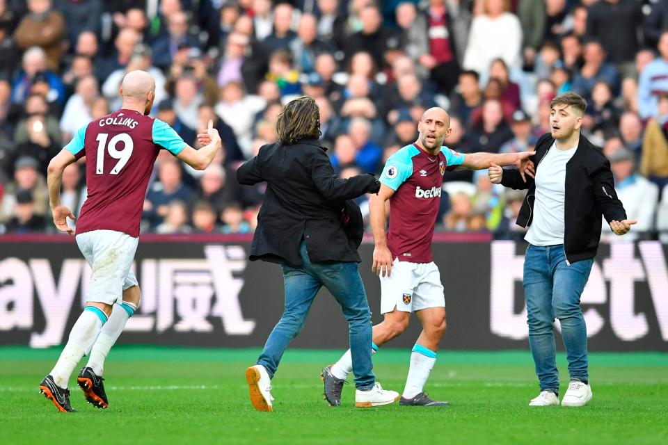  Pablo Zabaleta and James Collins interact with pitch invaders.