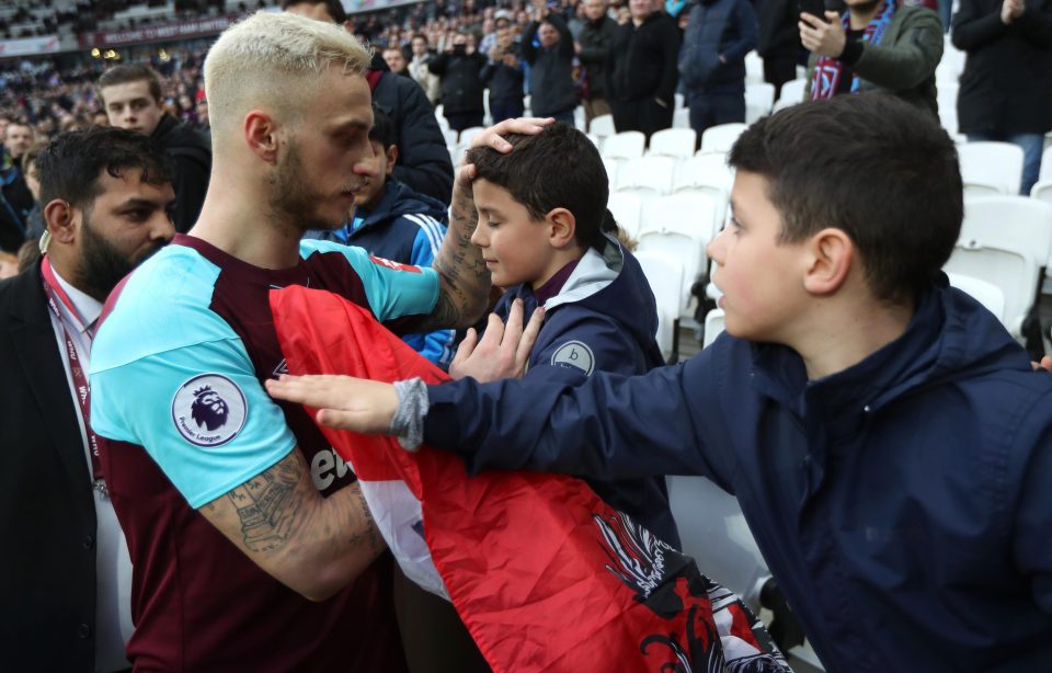  Marko Arnautovic checks on young fans as pitch invasion turns ugly.